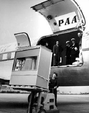 The RAMAC storage unit on a palette being lifted by a forklift out of an access door on
                        the side of a Pan American Airways aircraft.